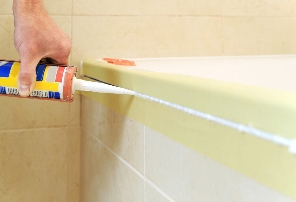 Poniendo silicona en el baño